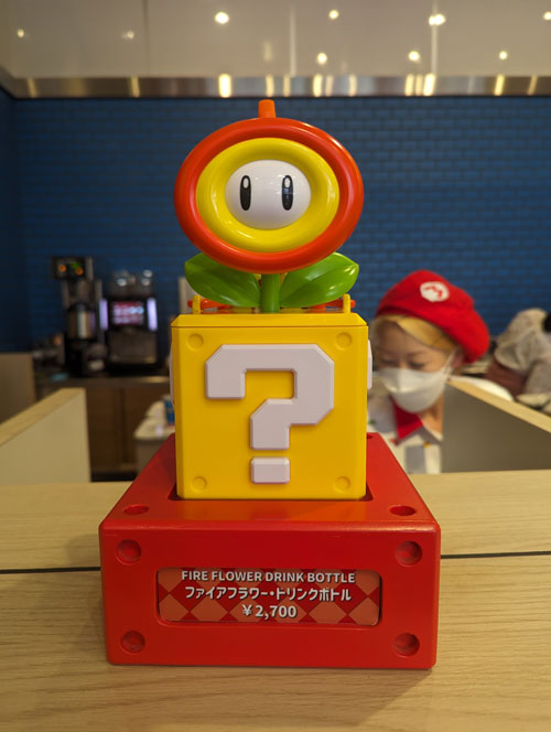 Botella de recuerdo con forma de Flor de fuego sobre un bloque de interrogación, en Super Nintendo World.