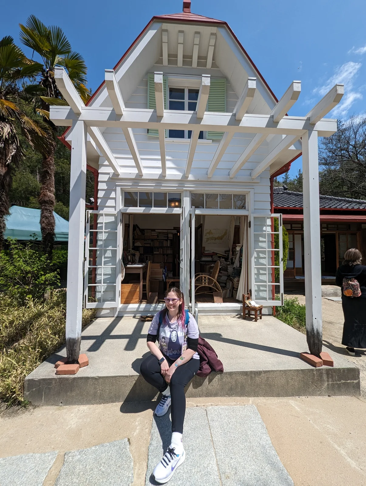 La esposa de Pablo, autor de Vamos Pa' Japón, sentada frente al estudio de la casa de Satsuki y Mei en Ghibli Park