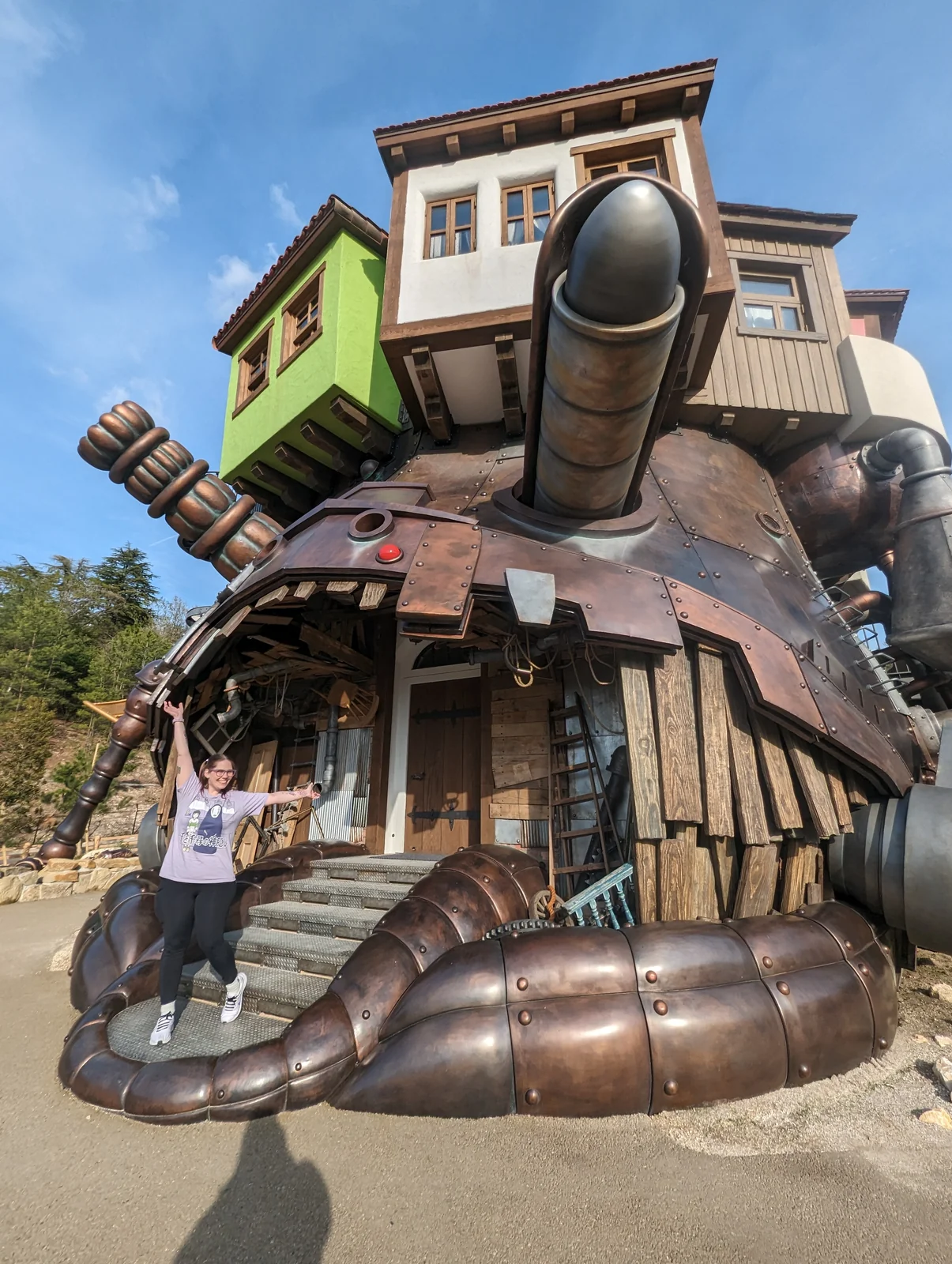 La esposa de Pablo, autor de Vamos Pa' Japón, con los brazos abiertos en la escalera del castillo de Howl en Ghibli Park