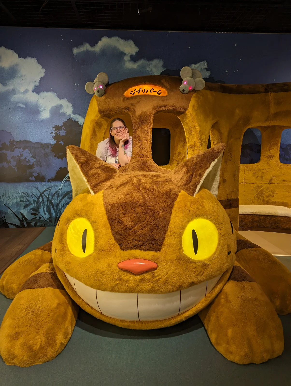 La esposa de Pablo, autor de Vamos Pa' Japón, asomada al Gatobús de peluche gigante del Gran Almacén de Ghibli Park