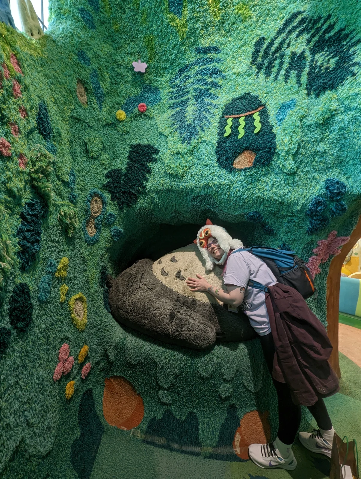 La esposa de Pablo, autor de Vamos Pa' Japón, abraza a Totoro dormido en el Gran Almacén de Ghibli Park