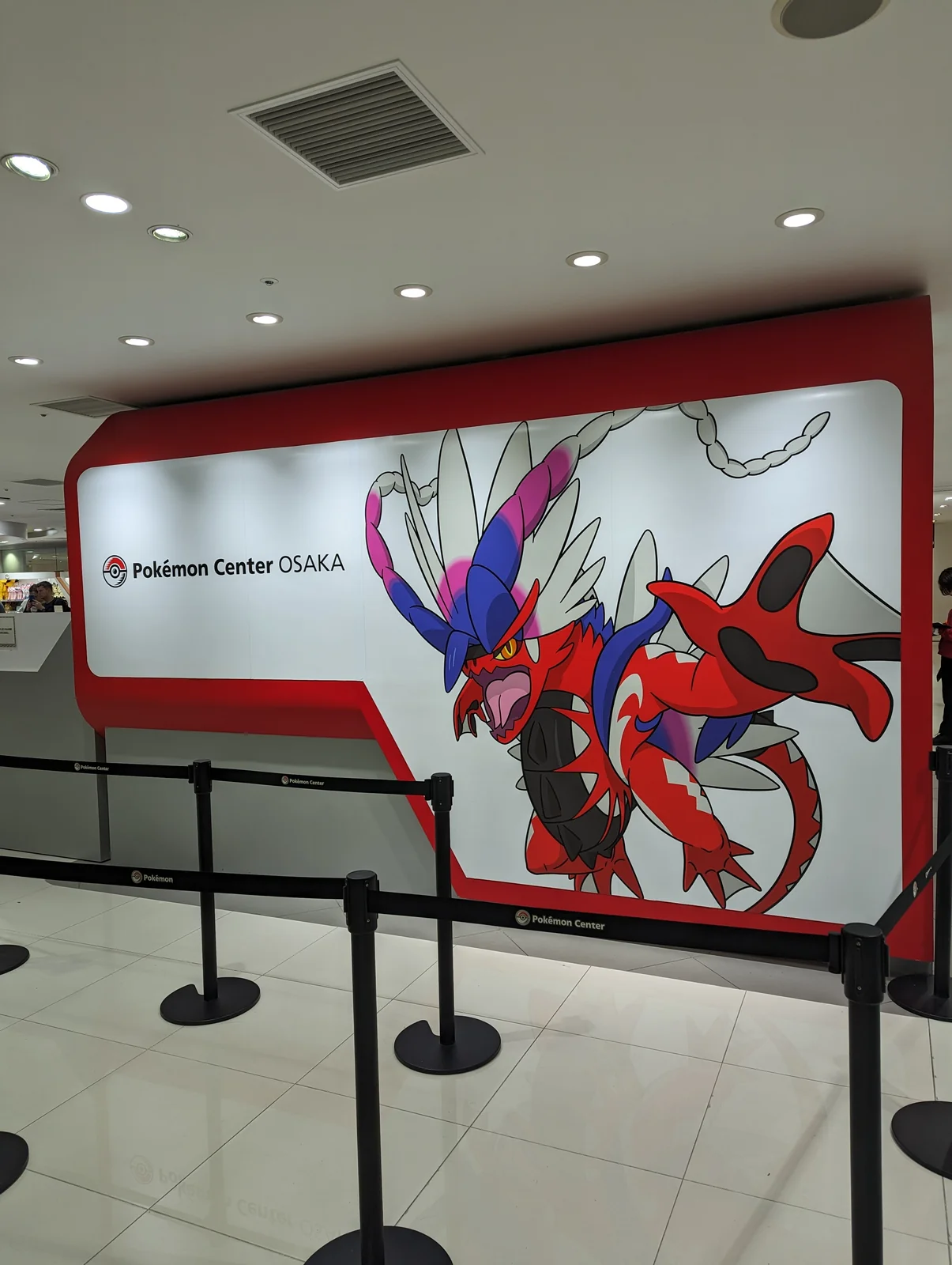 Mural de Koraidon con el letrero del Pokémon Center Osaka, en Umeda